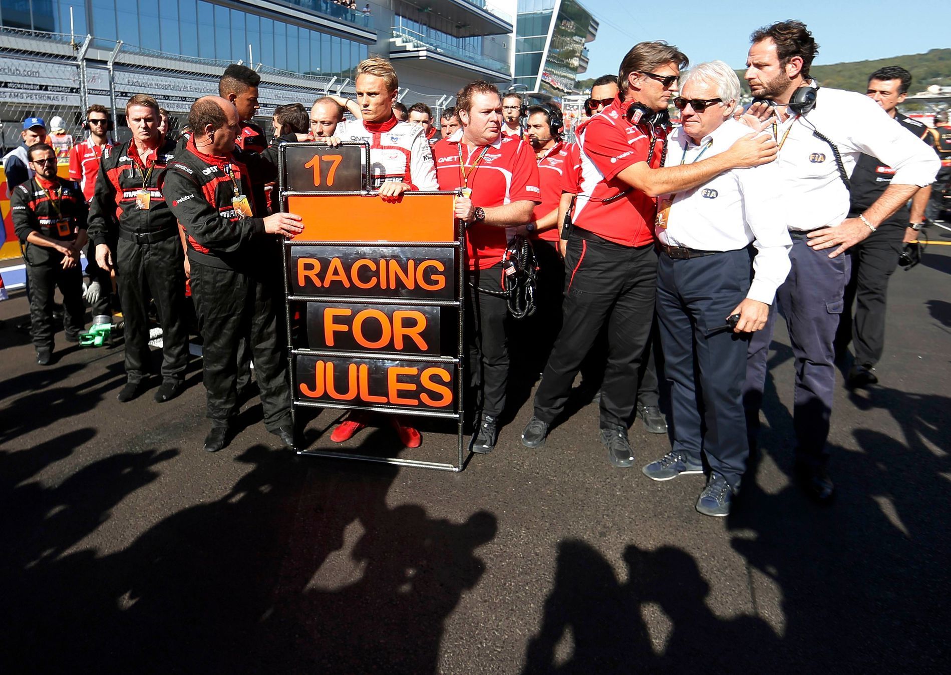 Marussia Formula One driver Chilton of Britain and his team members pray for Marussia Formula One driver Bianchi of France who had accident in previous race, before the first Russian Grand Prix in Soc