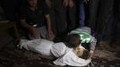 The brother of Palestinian boy Walid al-Abadlah, who according to hospital officials was killed in an Israeli air strike, kisses his body during his funeral in Khan Younis in the southern Gaza Strip November 15, 2012. A Hamas rocket killed three Israelis north of the Gaza Strip on Thursday, drawing the first blood from Israel as the Palestinian death toll rose to 15 including Walid al-Abadlah in a military showdown lurching closer to all-out war and an invasion of the enclave. REUTERS/Ibraheem Abu Mustafa (GAZA - Tags: CIVIL UNREST MILITARY POLITICS TPX IMAGES OF THE DAY) Published: Lis. 15, 2012, 2:54 odp.