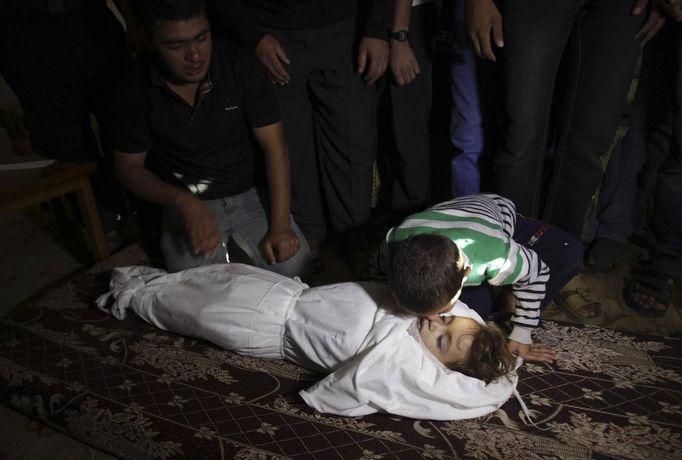 The brother of Palestinian boy Walid al-Abadlah, who according to hospital officials was killed in an Israeli air strike, kisses his body during his funeral in Khan Younis in the southern Gaza Strip November 15, 2012. A Hamas rocket killed three Israelis north of the Gaza Strip on Thursday, drawing the first blood from Israel as the Palestinian death toll rose to 15 including Walid al-Abadlah in a military showdown lurching closer to all-out war and an invasion of the enclave. REUTERS/Ibraheem Abu Mustafa (GAZA - Tags: CIVIL UNREST MILITARY POLITICS TPX IMAGES OF THE DAY) Published: Lis. 15, 2012, 2:54 odp.