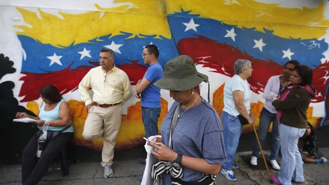 Venezuelané čekají na okamžik, až budou moci odevzdat svůj hlas v prezidentských volbách.