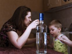 Matka s dítětem a lahví alkoholu