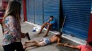 A civil police officer detain young suspects after a store was looted during a police strike in Recife, May 15, 2014. Road blocks and marches hit Brazilian cities on Thur