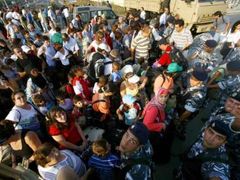 Libanonští policisté kontrolují doklady občanů USA před masivní evakuací, kterou Spojené státy organizují.