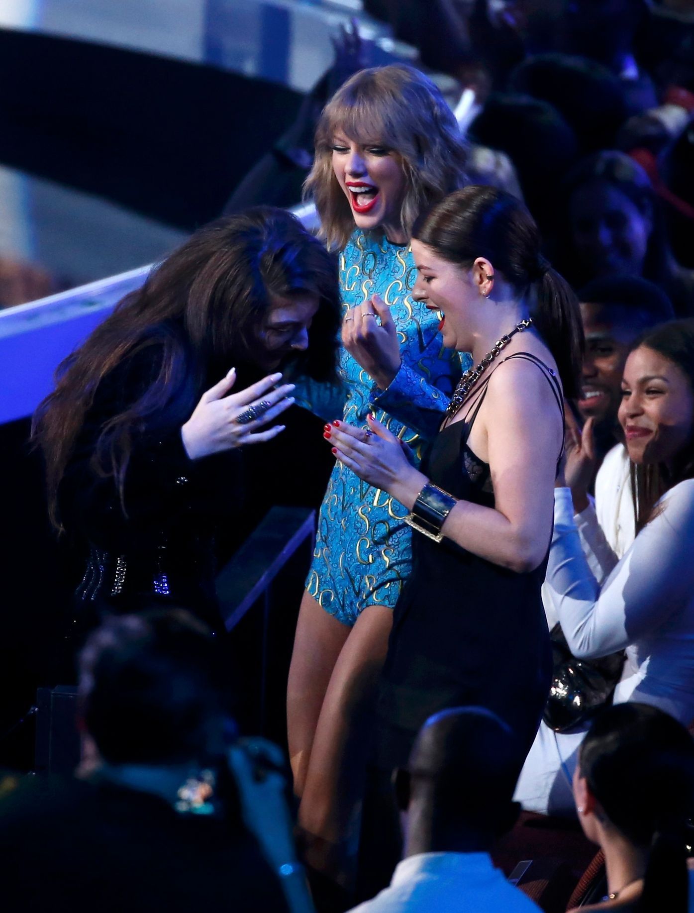 Lorde reacts with singer Taylor Swift and an unidentified guest during the 2014 MTV Video Music Awards in Inglewood
