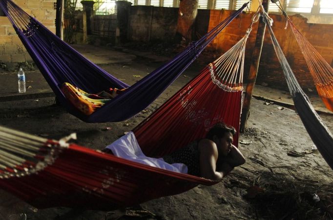 A native Indian rests on a hammock at the Brazilian Indian Museum in Rio de Janeiro March 21, 2013. A native Indian community of around 30 individuals have been living in the abandoned Indian Museum since 2006. They have expired a deadline given by a court last Friday to leave the museum within 3 days, local media reported. The group is fighting against the destruction of the museum, which is next to the Maracana Stadium. REUTERS/Pilar Olivares (BRAZIL - Tags: POLITICS SPORT SOCCER) Published: Bře. 21, 2013, 11:21 dop.