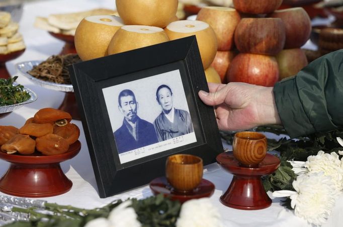 Kim Chang-hwa, 84, who was originally from North Korea's Seongcheon, South Pyeongan province, puts down the portrait of his North Korean parents during a memorial service for them in the direction of North Korea, near the demilitarized zone separating the two Koreas, in Paju, 55 km (34 miles) north of Seoul February 10, 2013, on the occasion of Seolnal, the Korean Lunar New Year's day. Millions of South Koreans travelled to their hometowns during the three-day holiday which started last Saturday. Seolnal is one of the traditional holidays when most Koreans visit their hometowns to be united with their families and hold memorial services for their deceased ancestors. REUTERS/Lee Jae-Won (SOUTH KOREA - Tags: MILITARY POLITICS SOCIETY) Published: Úno. 10, 2013, 6:24 dop.