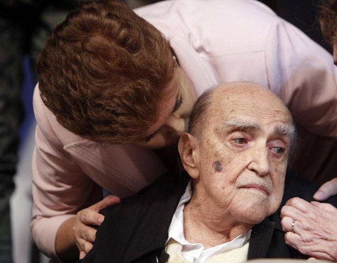 Brazil's President Dilma Roussef (top) kisses Brazilian architect Oscar Niemeyer during a meeting with artists and intellectuals when Rousseff was still a presidential candidate, in Rio de Janeiro, in this October 18, 2010 file photo. Niemeyer, a towering patriarch of modern architecture who shaped the look of modern Brazil and whose inventive, curved designs left their mark on cities worldwide, died late on December 5, 2012. He was 104. Niemeyer had been battling kidney ailments and pneumonia for nearly a month in a Rio de Janeiro hospital. His death was confirmed by a hospital spokesperson. REUTERS/Bruno Domingos/Files (BRAZIL - Tags: OBITUARY POLITICS SOCIETY) Published: Pro. 6, 2012, 2:39 dop.