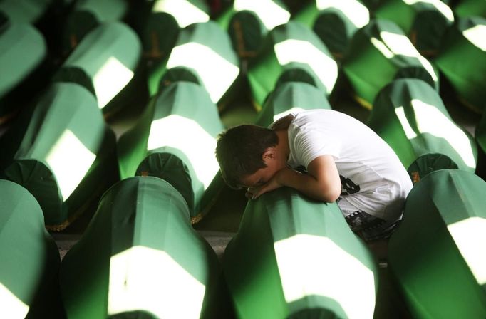 A Bosnian Muslim boy cries near coffins prepared for a mass burial at the Memorial Center in Potocari, near Srebrenica July 9, 2012. The bodies of 520 recently identified victims of the Srebrenica massacre will be buried on July 11, the anniversary of the massacre when Bosnian Serb forces commanded by Ratko Mladic slaughtered 8,000 Muslim men and boys and buried them in mass graves, in Europe's worst massacre since World War Two. REUTERS/Dado Ruvic (BOSNIA - Tags: POLITICS CONFLICT ANNIVERSARY) Published: Čec. 9, 2012, 6:32 odp.