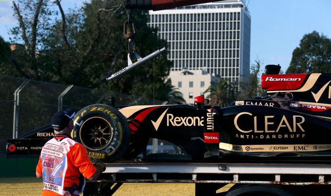 Workers load the car of Lotus Formula One driver Romain Grosjean of France onto a truck during the second practice session of the Australian F1 Grand Prix at the Albert P