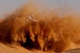 Zvířený písek od kol Mini francouzského pilota Stéphane Peterhansela během Rallye Dakar.