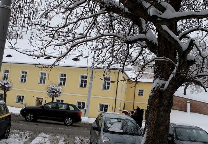 Černá Porsche Cayenne s obžalovanými Przybylou, Koláčkem a Otavou odjíždí od soudu po zasněžené ulici Hradce Králové.