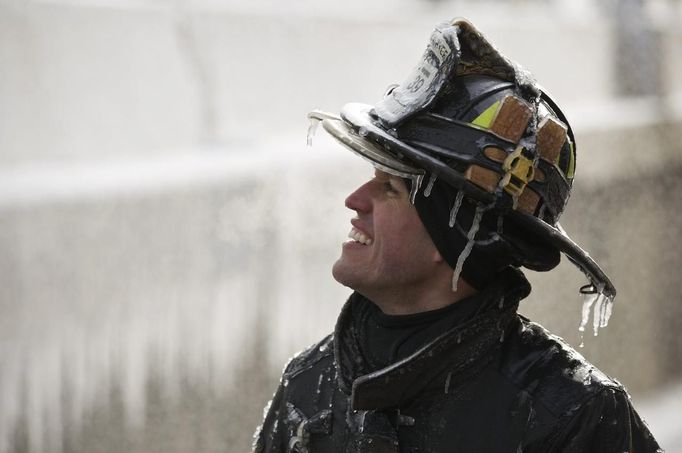 Firefighter Michael De Jesus is covered in ice as he mans a water cannon while fighting a warehouse fire in Chicago January 24, 2013, which caught fire Tuesday night. Fire department officials said it is the biggest fire the department has had to battle in years and one-third of all Chicago firefighters were on the scene at one point or another trying to put out the flames. REUTERS/John Gress (UNITED STATES - Tags: DISASTER ENVIRONMENT TPX IMAGES OF THE DAY) Published: Led. 24, 2013, 9:39 odp.