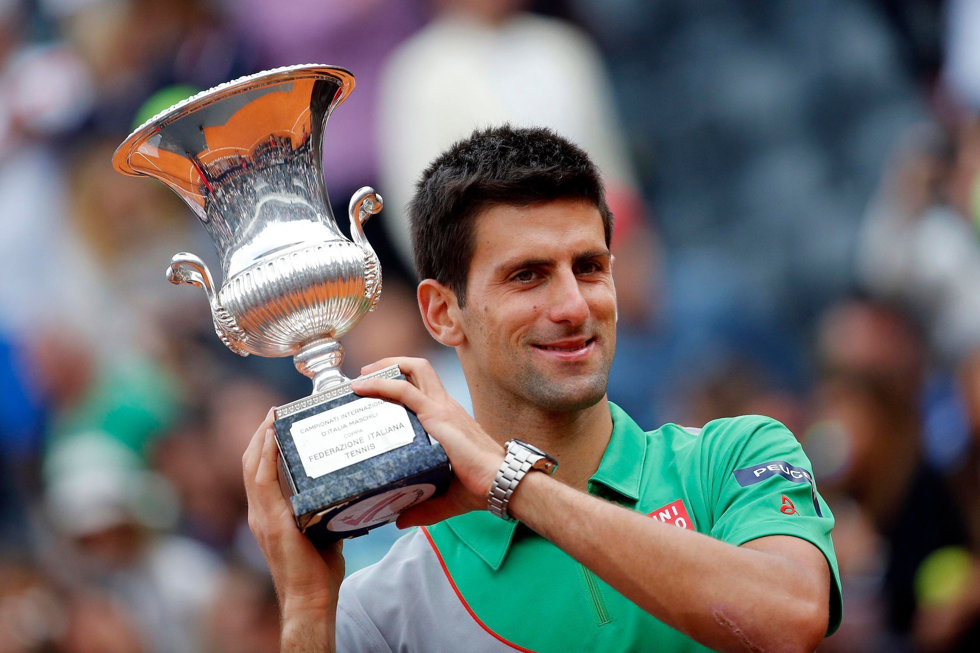 Djokovic of Serbia holds the trophy after winning the men's singles final match against Nadal of Spain at the Rome Masters tennis tournament