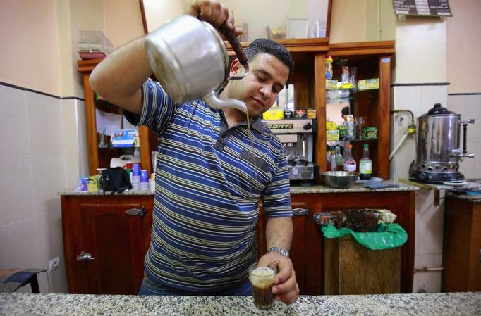 Sofiane Moussaoui, a 26 year-old waiter, poses for a picture as he serves tea for customers in a cafe in Algiers, April 22, 2012. Moussaoui studied for five years at the University 08 May 1945 Guelma where he received a masters degree in corporate finance. He hoped to find a job as an auditor but has been working as a waiter for over a year.