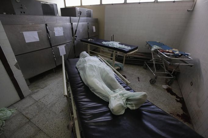 The covered-up dead body of a 16-year old boy who received a gunshot to his head lies on a stretcher at the morgue of a local hospital in San Pedro Sula March 24, 2013. San Pedro Sula, the country's second largest city after Tegucigalpa, has a homicide rate of 169 per 100,000 people and was named the world's most violent city for a second year in a row. Lax laws allow civilians to own up to five personal guns. Arms trafficking has flooded the country with nearly 70% illegal firearms. 83.4% of homicides are by firearms, compared to 60% in the United States. Picture taken March 24, 2013. REUTERS/Jorge Cabrera (HONDURAS - Tags: CRIME LAW CIVIL UNREST HEALTH) ATTENTION EDITORS: PICTURE 37 OF 39 FOR PACKAGE 'GUN CULTURE - HONDURAS' SEARCH 'HONDURAS GUN' FOR ALL IMAGES Published: Dub. 5, 2013, 11:15 dop.