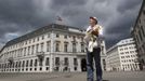 Head of the city beekeeper organization Felix Munk stands in front of the Austrian chancellery in Vienna, July 16, 2012. A growing number of urban beekeepers' associations, such as Vienna's Stadtimker, are trying to encourage bees to make their homes in cities, as pesticides and crop monocultures make the countryside increasingly hostile. Bee populations are in sharp decline around the world, under attack from a poorly understood phenomonenon known as colony collapse disorder, whose main causes are believed to include a virus spread by mites that feed on haemolymph - bees' "blood". Picture taken July 16, 2012. REUTERS/Lisi Niesner (AUSTRIA - Tags: ENVIRONMENT ANIMALS) Published: Čec. 25, 2012, 3:32 odp.