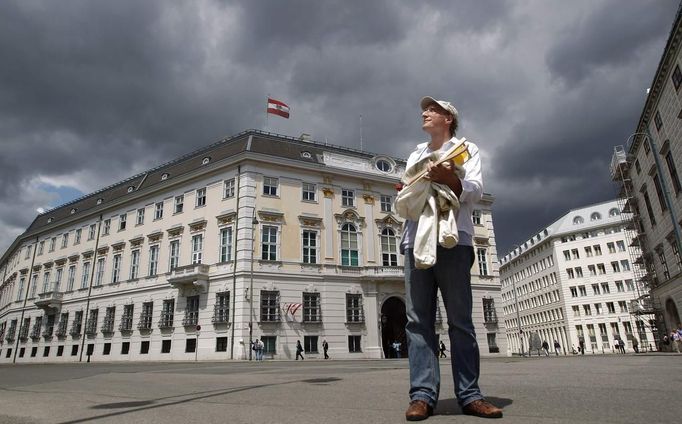 Head of the city beekeeper organization Felix Munk stands in front of the Austrian chancellery in Vienna, July 16, 2012. A growing number of urban beekeepers' associations, such as Vienna's Stadtimker, are trying to encourage bees to make their homes in cities, as pesticides and crop monocultures make the countryside increasingly hostile. Bee populations are in sharp decline around the world, under attack from a poorly understood phenomonenon known as colony collapse disorder, whose main causes are believed to include a virus spread by mites that feed on haemolymph - bees' "blood". Picture taken July 16, 2012. REUTERS/Lisi Niesner (AUSTRIA - Tags: ENVIRONMENT ANIMALS) Published: Čec. 25, 2012, 3:32 odp.