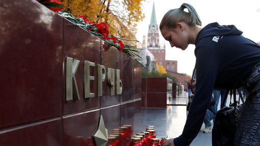 Lidé nosí svíčky a květiny v Moskvě.