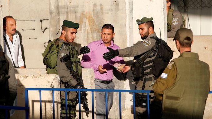 Izraelští pohraničníci kontrolují Palestince.