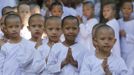 Novice Thai nuns fold their palms as they walk at the Sathira Dammasathan Buddhist meditation centre in Bangkok April 20, 2012. A small but growing group of Thai girls are choosing to spend part of the school holiday as Buddhist nuns, down to having their heads shaven. This year, to celebrate 2,600 years since the Buddha gained enlightenment, the Sathira Dammasathan centre arranged for the ordination of 137 women between the ages of five and 63. The ordination involved shaving their hair off and living as a Buddhist nun for 20 days, including going on rounds to collect alms from worshippers at dawn, wearing simple white cotton clothes, and daily meditation classes. Picture taken April 20, 2012. REUTERS/Sukree Sukplang (THAILAND - Tags: RELIGION) Published: Dub. 24, 2012, 8:20 odp.