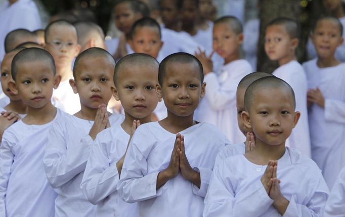 Novice Thai nuns fold their palms as they walk at the Sathira Dammasathan Buddhist meditation centre in Bangkok April 20, 2012. A small but growing group of Thai girls are choosing to spend part of the school holiday as Buddhist nuns, down to having their heads shaven. This year, to celebrate 2,600 years since the Buddha gained enlightenment, the Sathira Dammasathan centre arranged for the ordination of 137 women between the ages of five and 63. The ordination involved shaving their hair off and living as a Buddhist nun for 20 days, including going on rounds to collect alms from worshippers at dawn, wearing simple white cotton clothes, and daily meditation classes. Picture taken April 20, 2012. REUTERS/Sukree Sukplang (THAILAND - Tags: RELIGION) Published: Dub. 24, 2012, 8:20 odp.