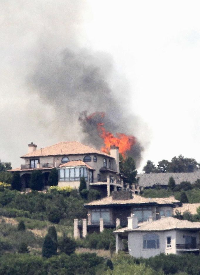 Flames explode next to house in a mountain subdivision, west of Colorado Springs June 24, 2012. A fast-growing wildfire has forced thousands of residents from homes in Colorado Springs, Colorado, and nearby communities as firefighters struggled on Sunday to contain out-of-control and wind-stoked blazes in several western U.S. states. REUTERS/Rick Wilking (UNITED STATES - Tags: DISASTER ENVIRONMENT) Published: Čer. 24, 2012, 10:54 odp.