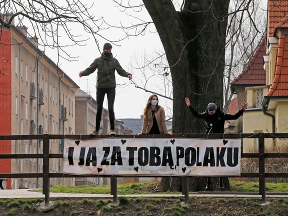 Lidé pózují v Českém Těšíně u plakátu "I JA ZA TOBA POLAKU" ("I mně po tobě, Poláku"), kterým odpověděli na polský vzkaz "Stýská se mi po Tobě Čechu".