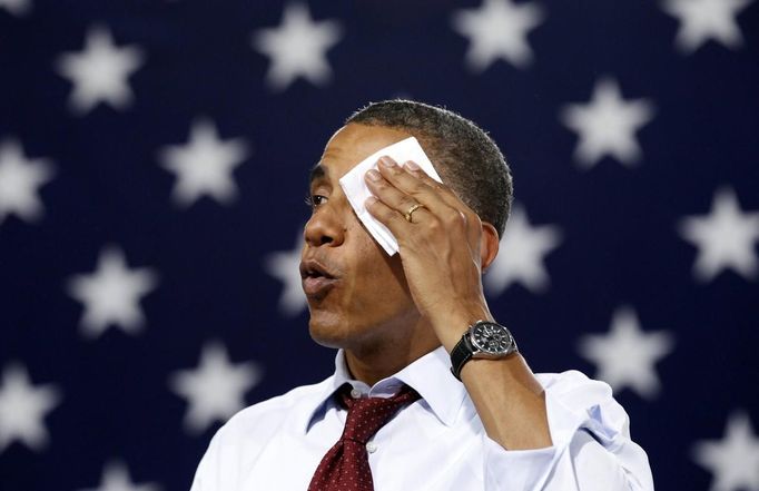 RNPS IMAGES OF THE YEAR 2012 - U.S. President Barack Obama wipes perspiration from his face as he speaks in a sweltering gym during a campaign stop at Windham High School in Windham, New Hampshire, August 18, 2012. REUTERS/Kevin Lamarque (UNITED STATES - Tags: POLITICS ELECTIONS TPX IMAGES OF THE DAY) Published: Pro. 5, 2012, 10:59 odp.