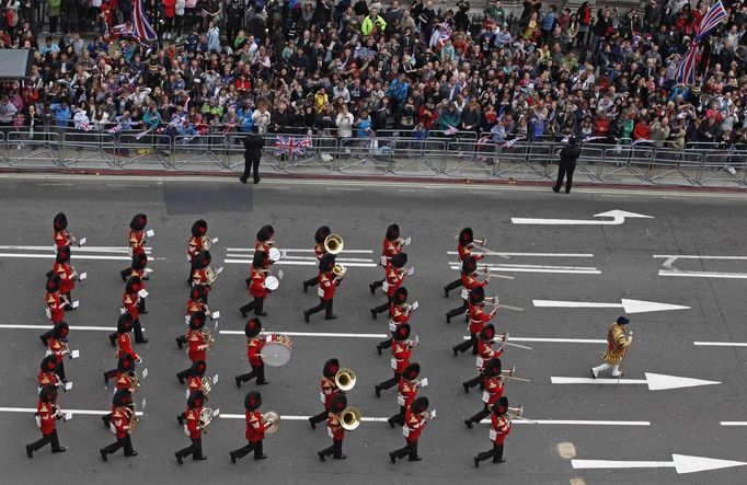 A military marching band plays music as crowds line up to watch the carriage procession carrying the Royal family, during Queen Elizabeth's Diamond Jubilee in London June 5, 2012. REUTERS/Elizabeth Dalziel/Pool (BRITAIN - Tags: ROYALS ENTERTAINMENT MILITARY) Published: Čer. 5, 2012, 1:09 odp.