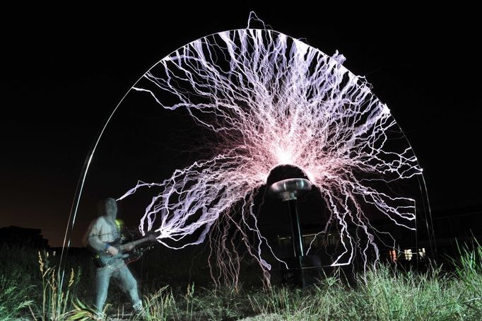 Performing With Lightning CHANGLE, CHINA - AUGUST 13: (CHINA OUT) A guitarist plays guitar as high voltage of up to 1 million volts, generated by a Tesla coil transformer, runs through his body during a stunt performance on August 13, 2012 in Changle, Fujian Province of China. Wang Zengxiang, one of the craziest fans of the Tesla coil stunt, has dedicated himself in the daredevil career for a decade. He is now the leader of a band of four. A Tesla coil is an electrical resonant transformer circuit invented by Nikola Tesla around 1891. The transformer produces high voltage at high frequencies, which acts as a giant lightning machine, and creates long bolts of electricity. Shielded by protective clothing, the performer is insulated from the electricity current which dissipates through the ground. (