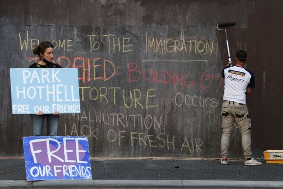 Lidé před detenčním centrem Park Hotel v australském Melbourne demonstrují za práva uprchlíků.
