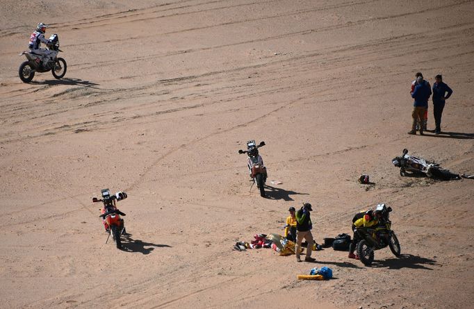Další závodníci se snaží pomoci Paulo Goncalvesovi, jenž havaroval během 7. etapy Rallye Dakar následkům svých zranění podlehl. U žluté motorky stojí Slovák Štefan Svitko
