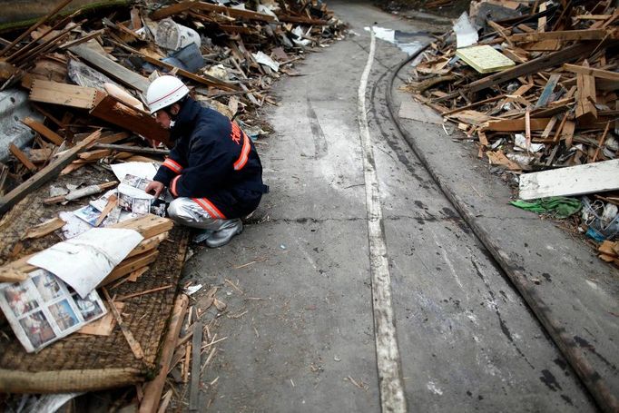 Hasič v Ocuči se probírá nálezy ze sutin. Fotoalbem.