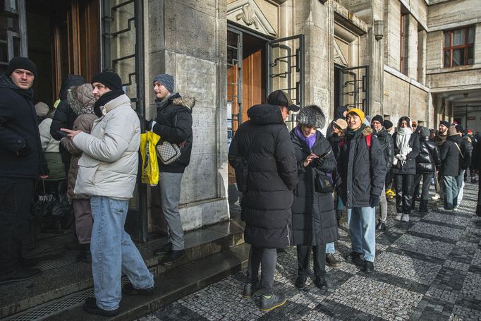 Městská knihovna v Praze a turisté čekající na fotku se sloupem z knih, tzv. Idiomem.