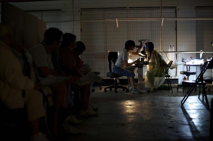 A patient has an eye exam at the Remote Area Medical (RAM) clinic in Wise, Virginia July 20, 2012. RAM clinics bring free medical, dental and vision care to uninsured and under-insured people across the country and abroad. The Wise clinic was the 647th RAM expedition since 1985 and drew 1700 patients from 14 states, organizers said. Picture taken July 20, 2012. REUTERS/Mark Makela (UNITED STATES - Tags: HEALTH SOCIETY) Published: Čec. 24, 2012, 3:16 odp.