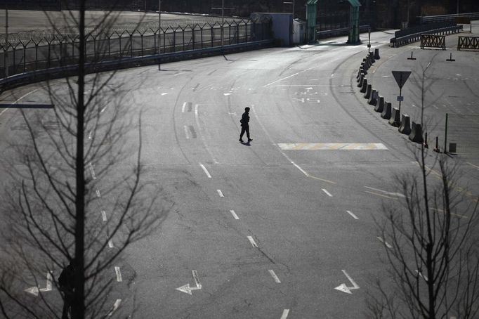 A South Korean soldier walks on an empty road connecting the Kaesong Industrial Complex (KIC) with the South's CIQ (Customs, Immigration and Quarantine) office, just south of the demilitarised zone which separates the two Koreas, in Paju, north of Seoul March 11, 2013. North Korea has torn up the armistice that ended its 1950s conflict and shut down a humanitarian hotline with the South, but one project keeps operating at full swing -- an industrial park run with the South on its own side of the world's most heavily militarised border. REUTERS/Kim Hong-Ji (SOUTH KOREA - Tags: MILITARY POLITICS TPX IMAGES OF THE DAY) Published: Bře. 11, 2013, 1:38 odp.