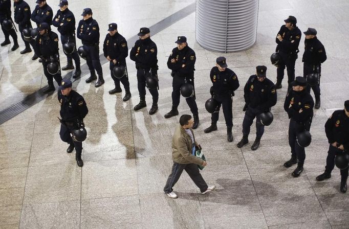 A passenger passes a line of police at Atocha rail station during a 24-hour nationwide general strike in Madrid, November 14, 2012. Spanish and Portuguese workers staged the first coordinated strike across the Iberian peninsula on Wednesday, shutting down transport, grounding flights and closing schools to protest austerity measures and tax hikes. REUTERS/Paul Hanna (SPAIN - Tags: POLITICS CIVIL UNREST BUSINESS EMPLOYMENT TRANSPORT) Published: Lis. 14, 2012, 9:28 dop.