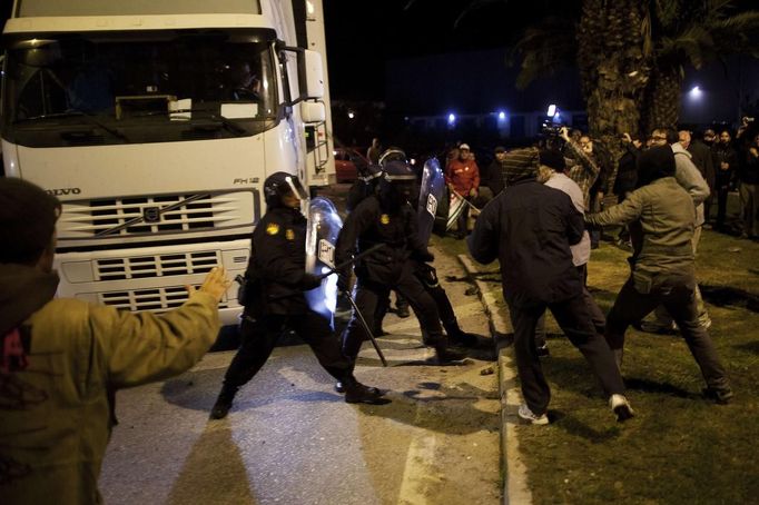 Picketers (R) clash with riot police officers as they try to stop a truck (L) at the entrance of Malaga's main food warehouse "MercaMalaga", during the start of a nationwide general strike in Malaga, southern Spain early November 14, 2012. Spanish and Portuguese workers will stage the first coordinated general strike across the Iberian Peninsula on Wednesday, shutting transport, grounding flights and closing schools to protest against spending cuts and tax hikes. REUTERS/Jon Nazca (SPAIN - Tags: BUSINESS EMPLOYMENT CIVIL UNREST POLITICS) Published: Lis. 14, 2012, 7:39 dop.