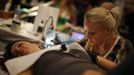 Shannon Toohey, 23, works on one of her clients during the National Tattoo Association Convention in Cincinnati, Ohio April 14, 2012. Toohey, who has been surrounded by tattoo artists during most of her young life, drew her first tattoo on her mother at the age of ten and now works at a tattoo shop on Long Island, New York. Picture taken April 14, 2012. REUTERS/Jason Reed (UNITED STATES - Tags: SOCIETY) ATTENTION EDITORS PICTURE 11 OF 31 FOR PACKAGE 'ADDICTED TO THE NEEDLE' TO FIND ALL PICTURES SEARCH 'ADDICTED NEEDLE' Published: Čer. 29, 2012, 12:59 odp.