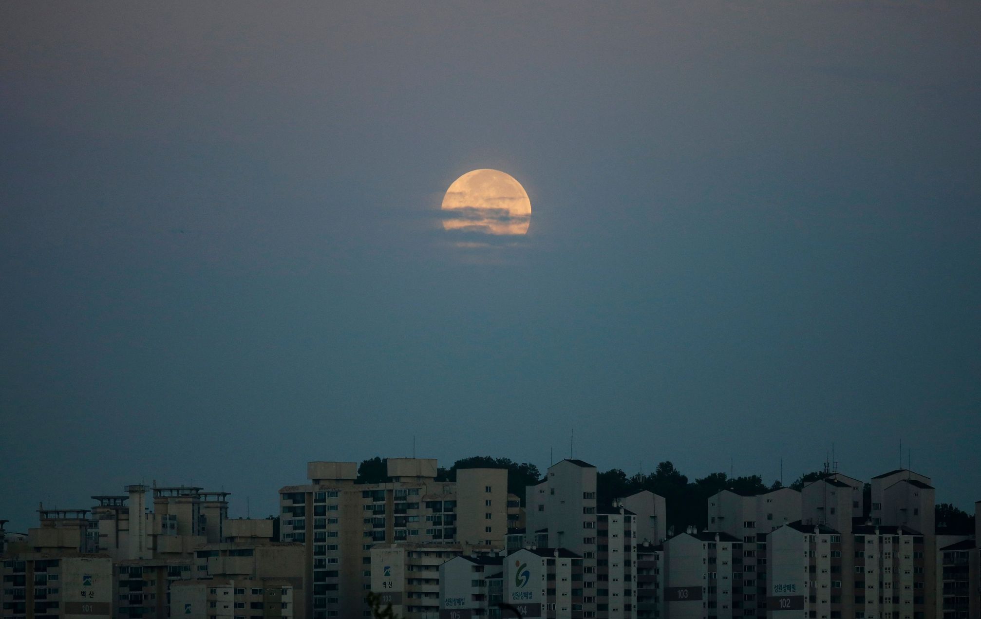 Supermoon hangs in the sky behind an apartment complex in Suwon