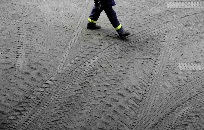 A man walks through tyre tracks at the SSI steel plant at Redcar, northern England May 29, 2012. SSI Steel from Thailand took over the plant on February 24, 2011 after it had been closed by Tata steel. The blast furnace was relit on April 15 this year and the plant now employs 1800 workers and has produced and exported 136,000 tonnes of steel. REUTERS/Nigel Roddis (BRITAIN - Tags: BUSINESS ENERGY EMPLOYMENT) Published: Kvě. 29, 2012, 3:35 odp.