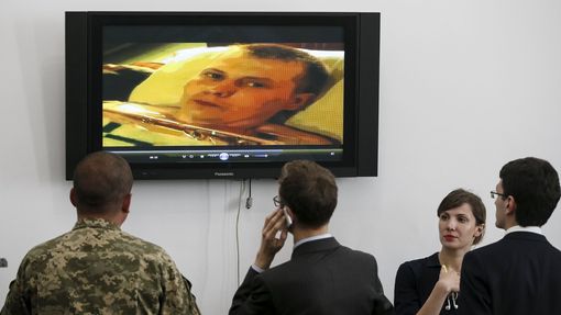 Ukrajinští novináři a vojáci sledují v Kyjevě video z výslechu zajatého ruského vojáka.