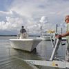 Nick Hobbs, left, and Randy Shaw, right, of Marine Warehouse Center, remove a customer's boat from the water in advance of Hurricane Florence in Wrightsville Beach, N.C.