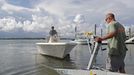 Nick Hobbs, left, and Randy Shaw, right, of Marine Warehouse Center, remove a customer's boat from the water in advance of Hurricane Florence in Wrightsville Beach, N.C.