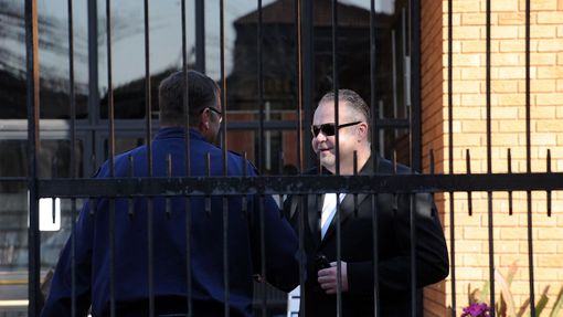 Radovan Krejčíř zdraví policistu před budovou pretorijského soudu, který rozhodoval o jeho vydání do Česka. (29. srpna 2013)
