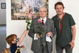 Chlapec podává růži Jiřímu Suchému, který s Janem Homolou pózuje na vernisáži výstavy Pelmel.