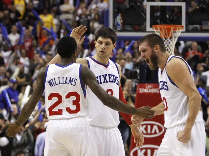 Lou Williams (vepředu) se raduje se Spencerem Hawesem a Nikolou Vučevičem z výhry 76ers