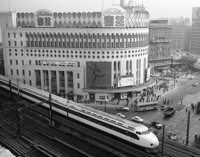 Japonský rychlovlak Šinkansen projíždí kolem divadla Nichigeki v tokijské čtvrti Yurakucho po odjezdu z Tokijské stanice, 21. prosince 1964.