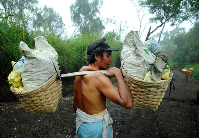 To go with story Indonesia-volcano-mine by Jerome Rivet A picture taken on April 26, 2010 shows Indonesian sulphur miner carrying blocks of sulphur down the Kawah Ijen, or Ijen crater, in Bondowoso in East Java. Indonesian porters at Kawah Ijen, a famous tourist spot in Indonesia's East Java, mine and carry at least 70 kg-worth of sulphur blocks on their shoulders through the suffocating clouds of toxic gases each day receiving just 70,000 to 80,000 rupiah (7 - 8 US dollars) for their labour.