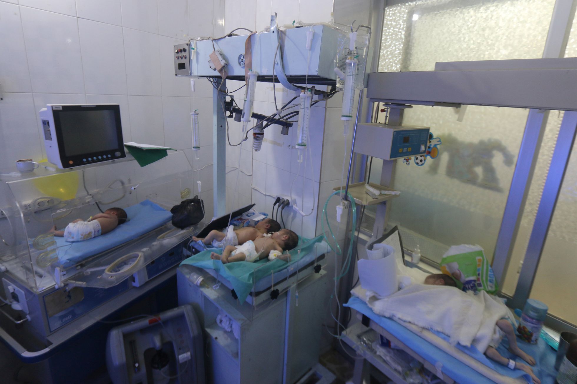Babies are seen inside a nursery at a children's hospital that was partially damaged from recent airstrikes, in a rebel held area of Aleppo